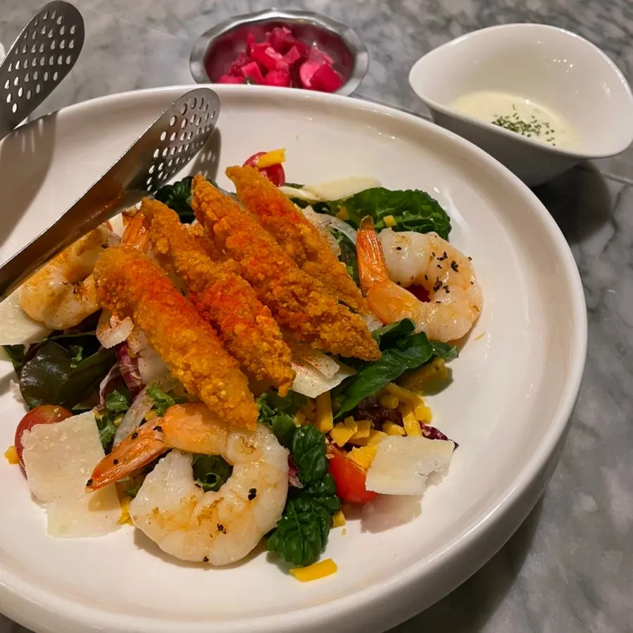 Salad topped with shrimp and chicken tenders