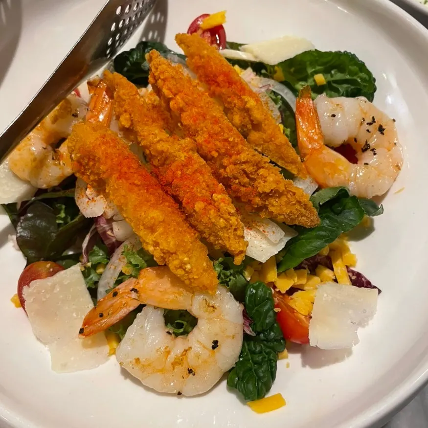 Salad topped with three large shrimp