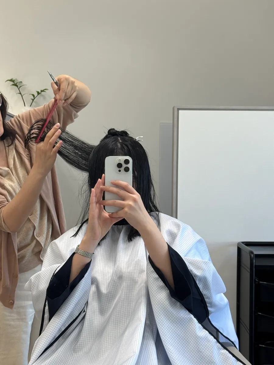 Designer cutting wet hair after shampooing