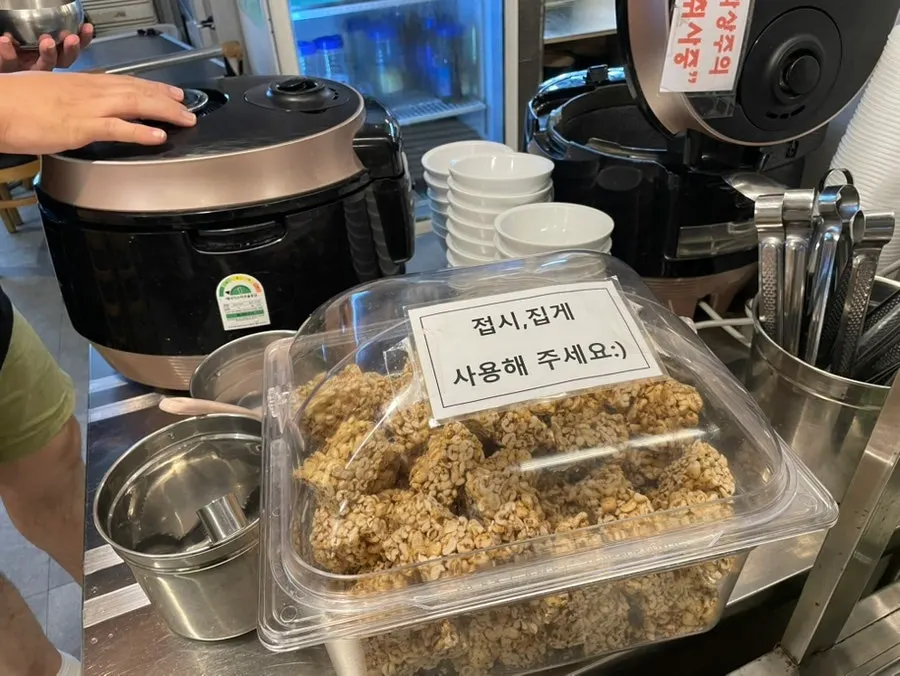 Rice cooker and barley candy dessert beside the self-serve bar