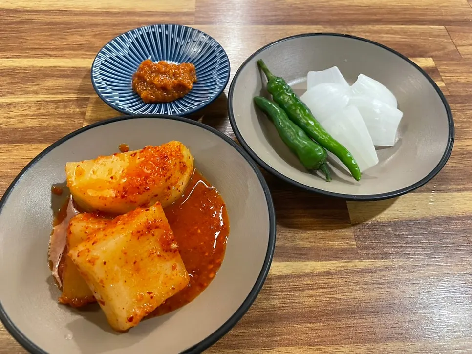 Basic side dishes: seokbakji, chili peppers, onion, and ssamjang