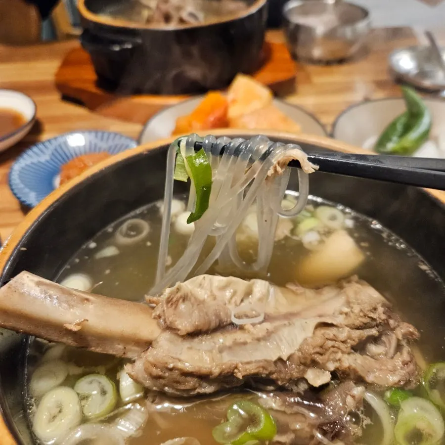 젓가락으로 들어 올린 갈비탕 당면