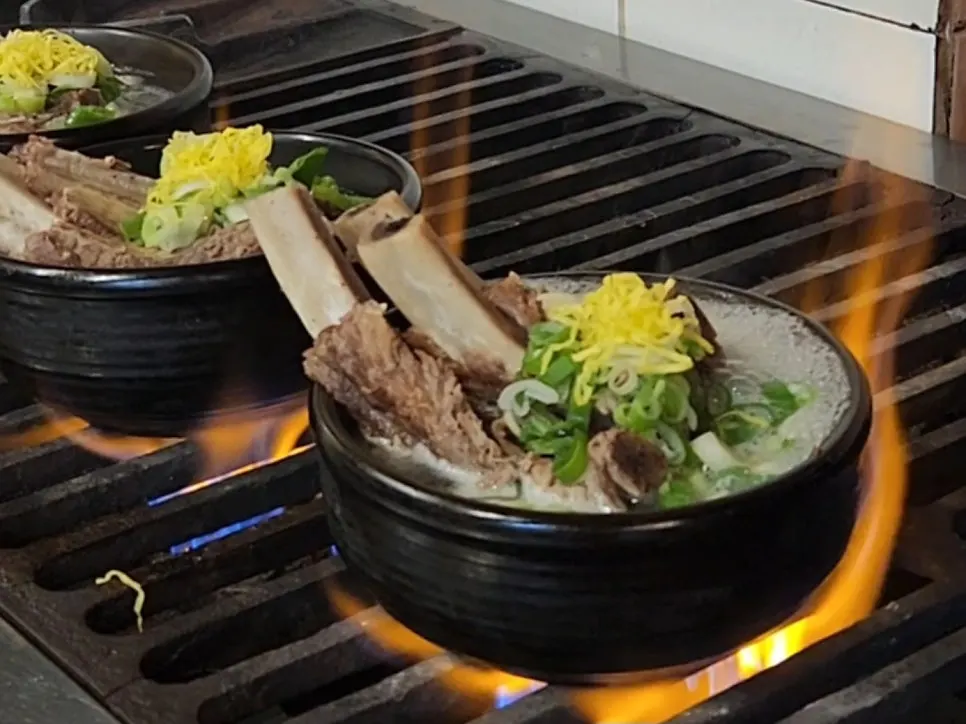 Open kitchen at Achasan Tong Galbitang with stone pots simmering