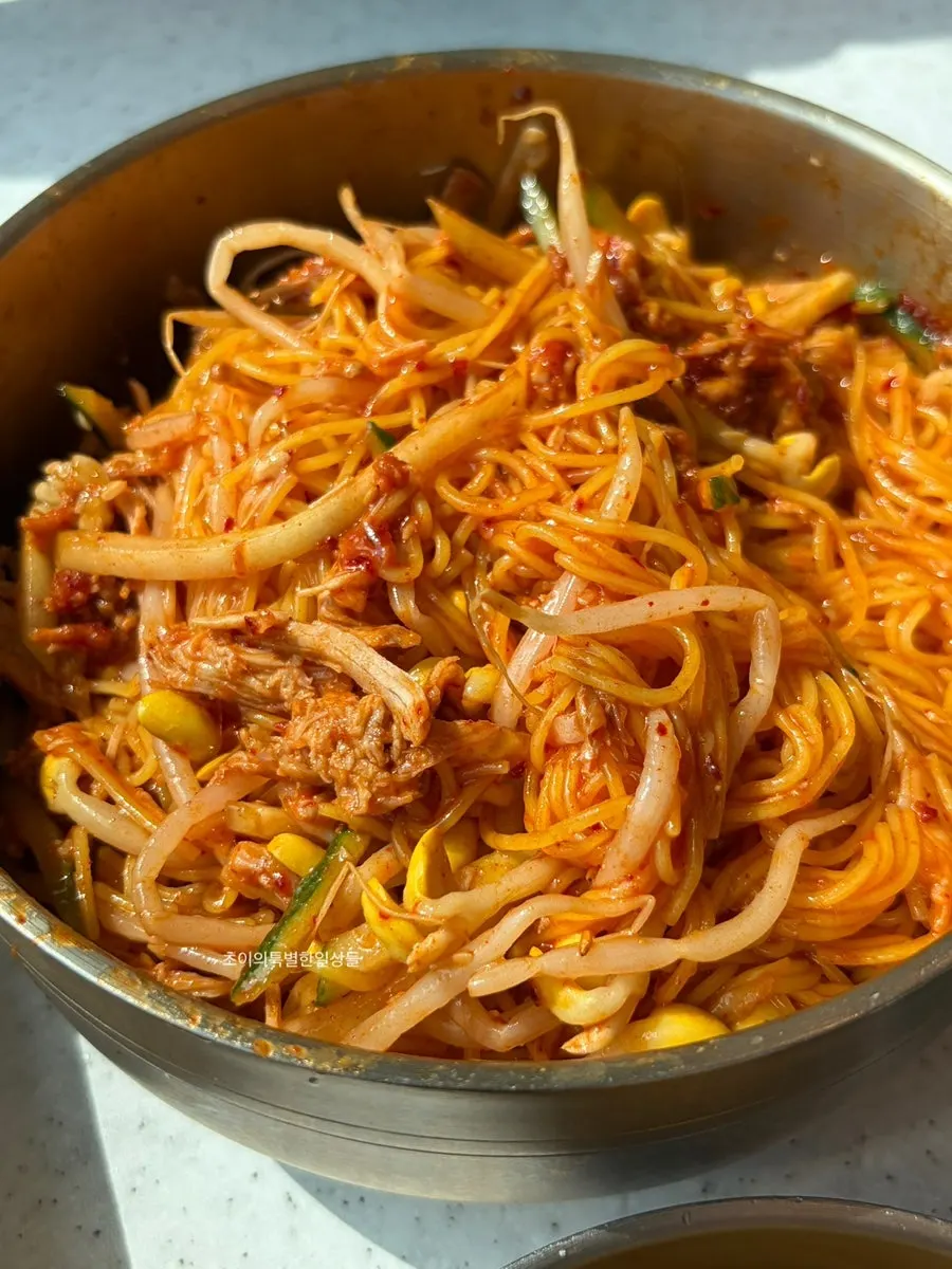 Wrapping bibim noodles with dombe naengsuyuk to eat together