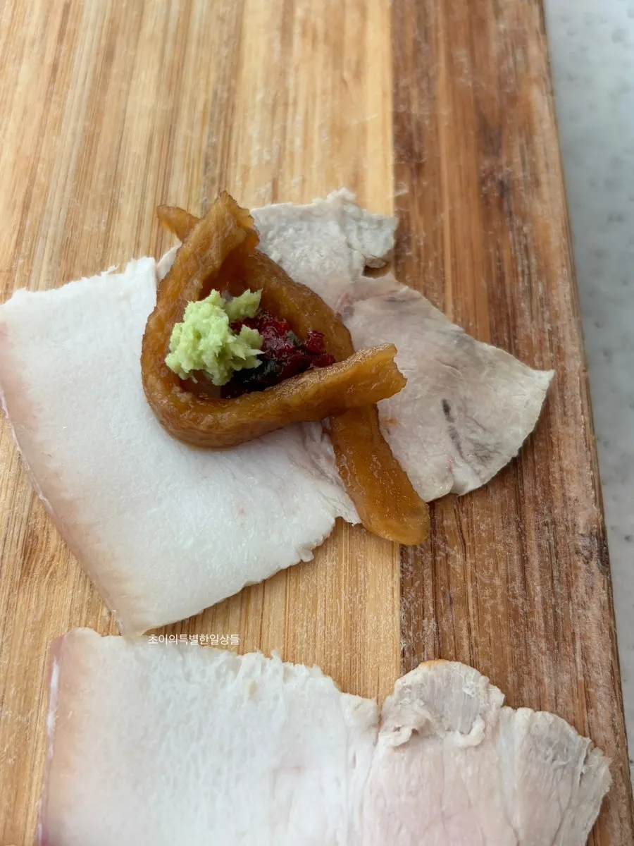Dombe naengsuyuk topped with pickled radish and wasabi