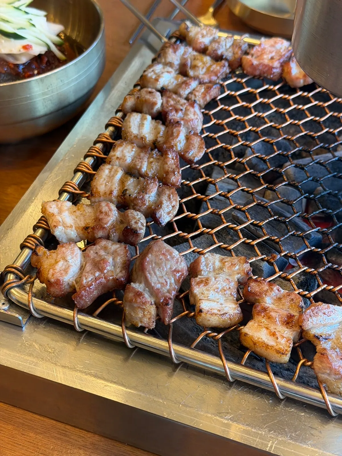 Staff member grilling black pork at the Aewol restaurant
