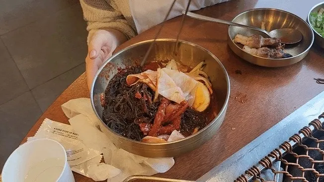 고기를 쌈과 소스에 조합해 먹는 모습