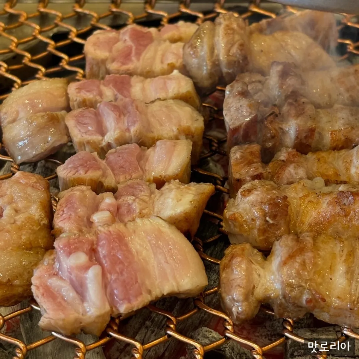 Thịt ba chỉ heo đen đang được nướng trên vỉ