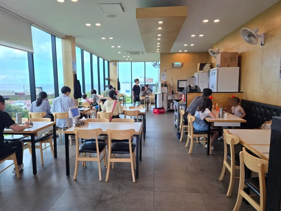 Dining hall with sea view through floor-to-ceiling windows
