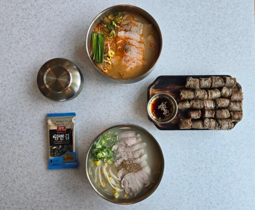 Table spread of bone-broth pork noodles, mala pork noodles, and leek pork sundae