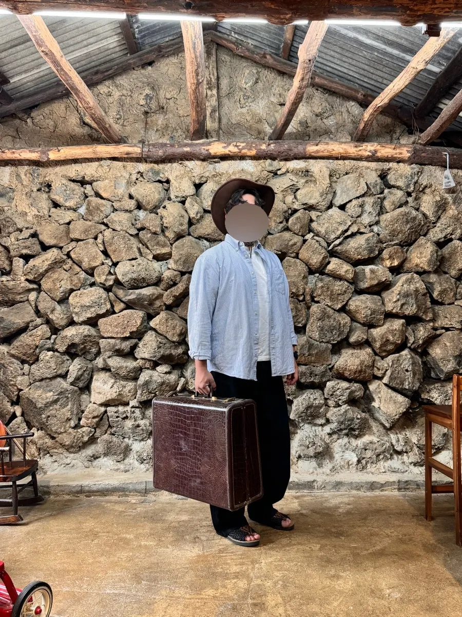 Concept self-photo shot with an oversized bag and hat props
