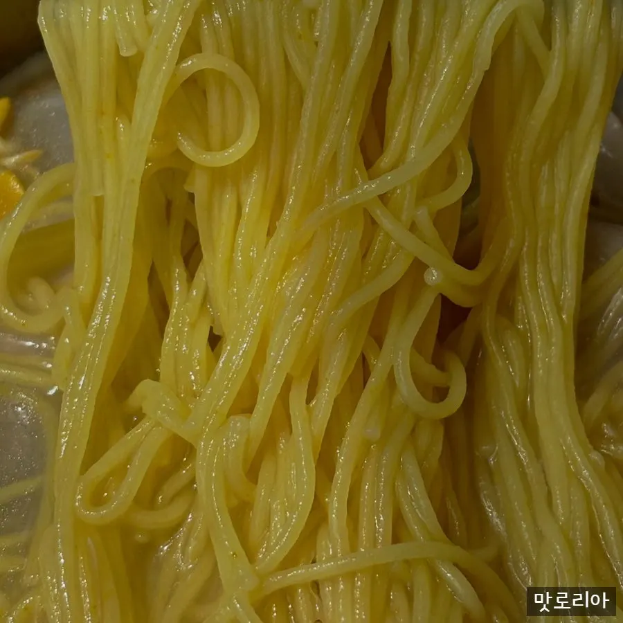Noodles topped with large pieces of meat