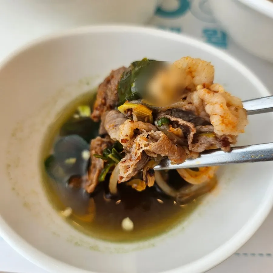 Dipping soup ingredients into the sauce