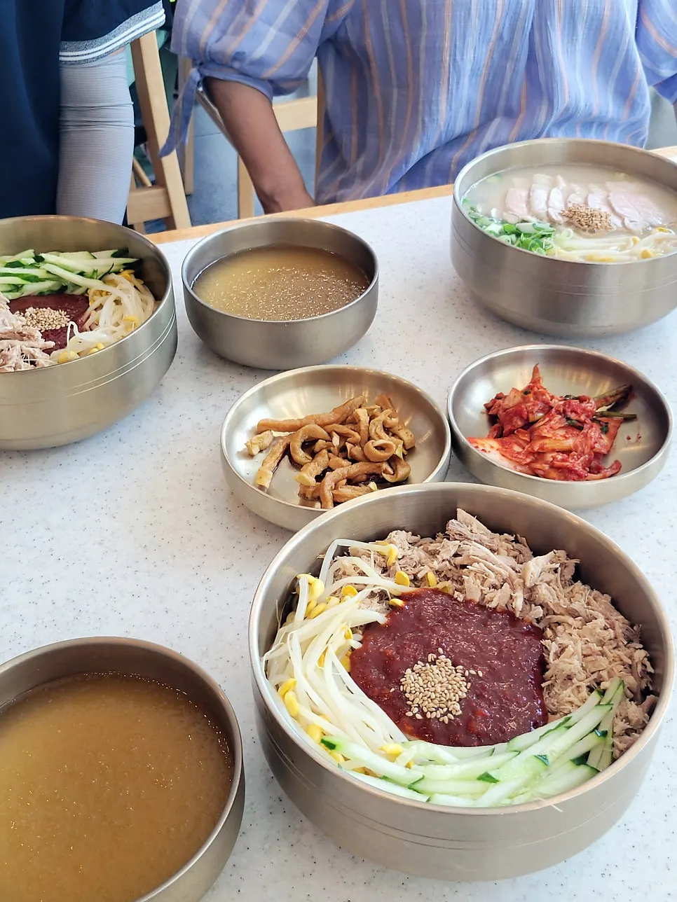 Table set with bone broth pork noodles and dongchimi bibim noodles