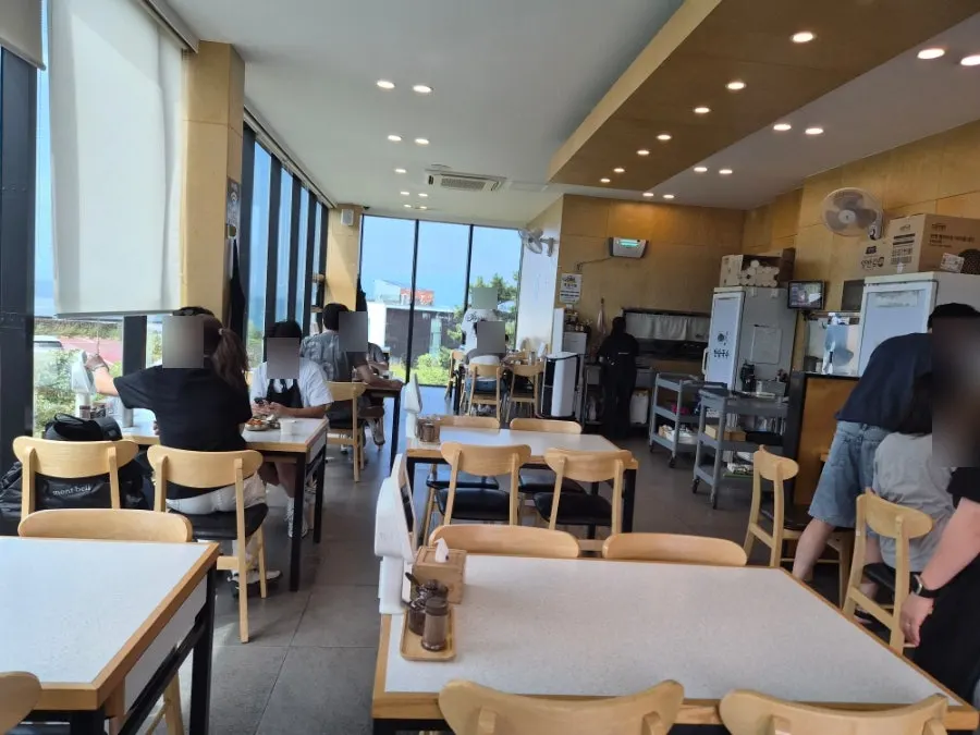 Restaurant interior with the Jeju sea visible through the glass window