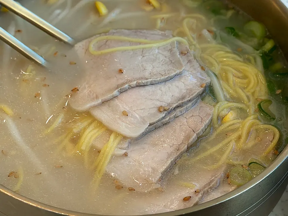 뽀얀 사골 국물에 고기가 올라간 고기국수