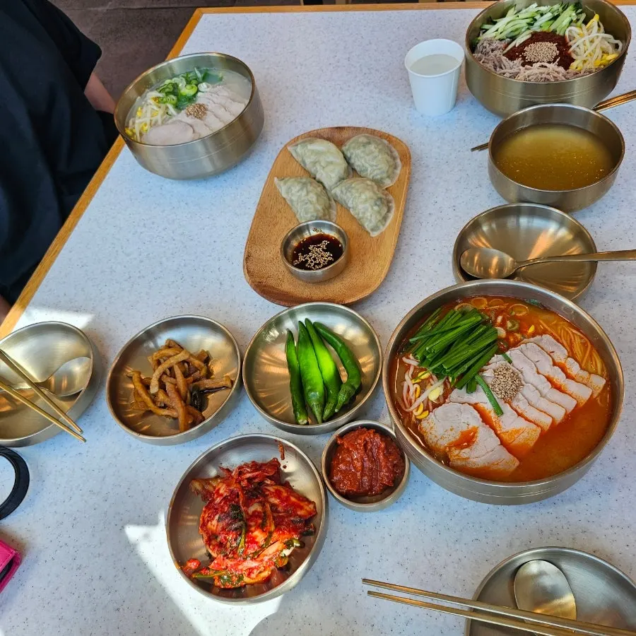 A bowl of bone-broth pork noodles piled high with meat toppings