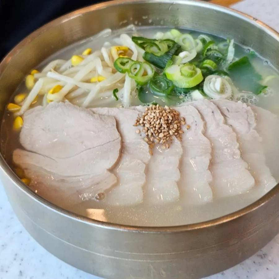 Bone-broth pork noodles alongside self-serve side dishes