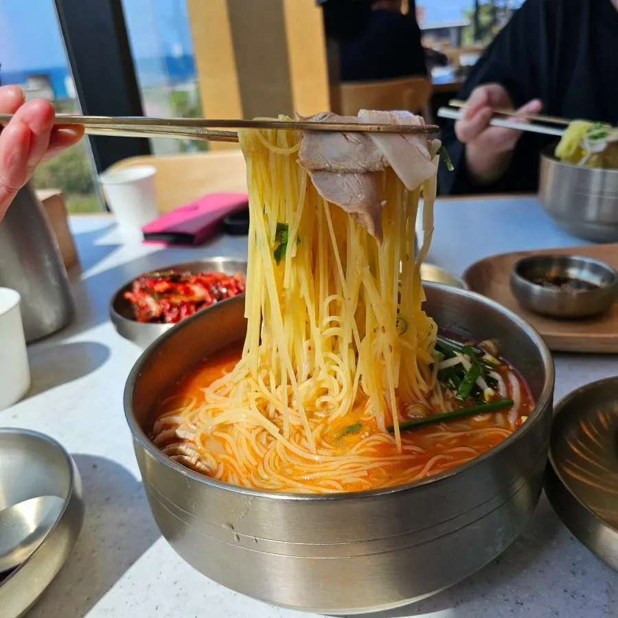 Table with bibim noodles and meat dumplings side by side