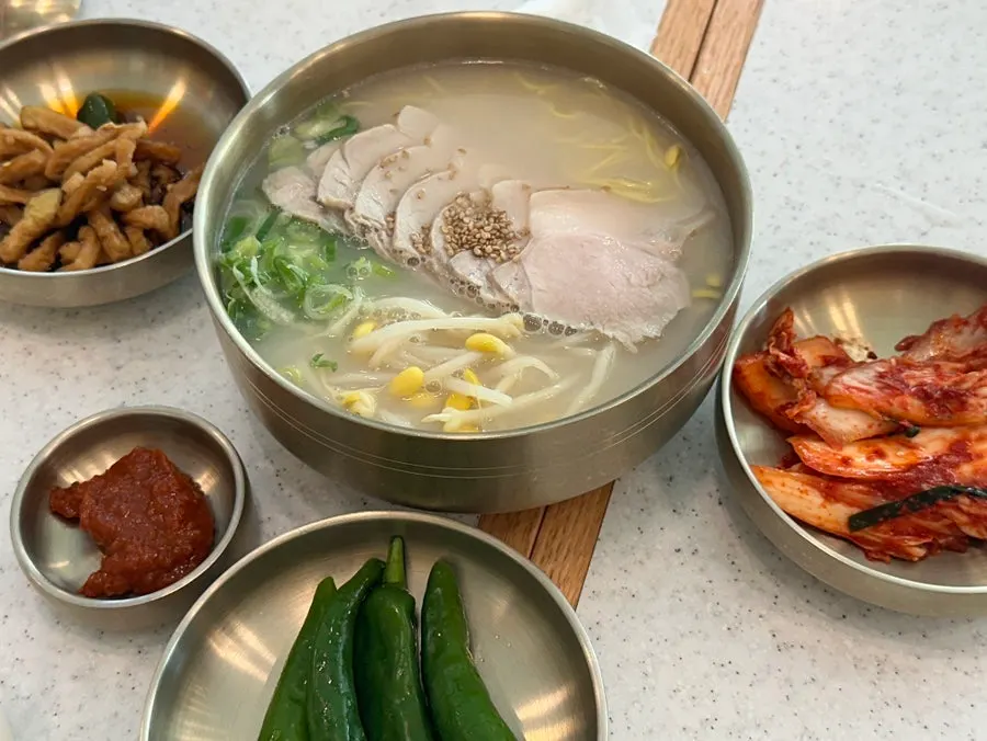 Pork noodle soup topped with thin pork slices and bean sprouts