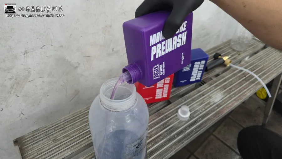 Pouring alkaline pre-wash into a dedicated bottle