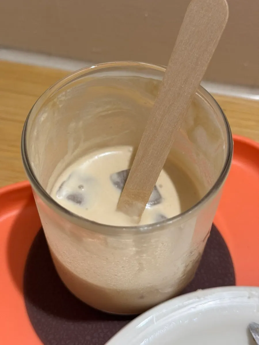 Latte glass emptying alongside the sando