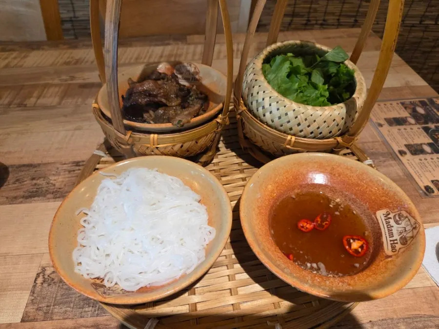 A full bun cha set with grilled pork, rice noodles, and vegetables