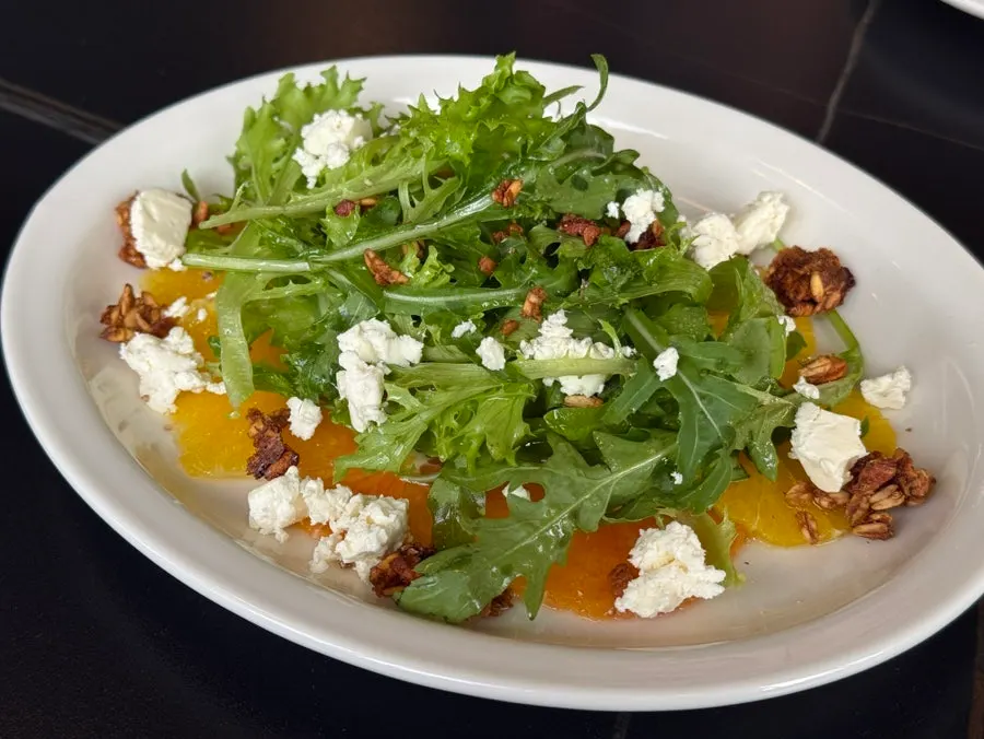 Mediterranean salad topped with citrus fruit and feta cheese