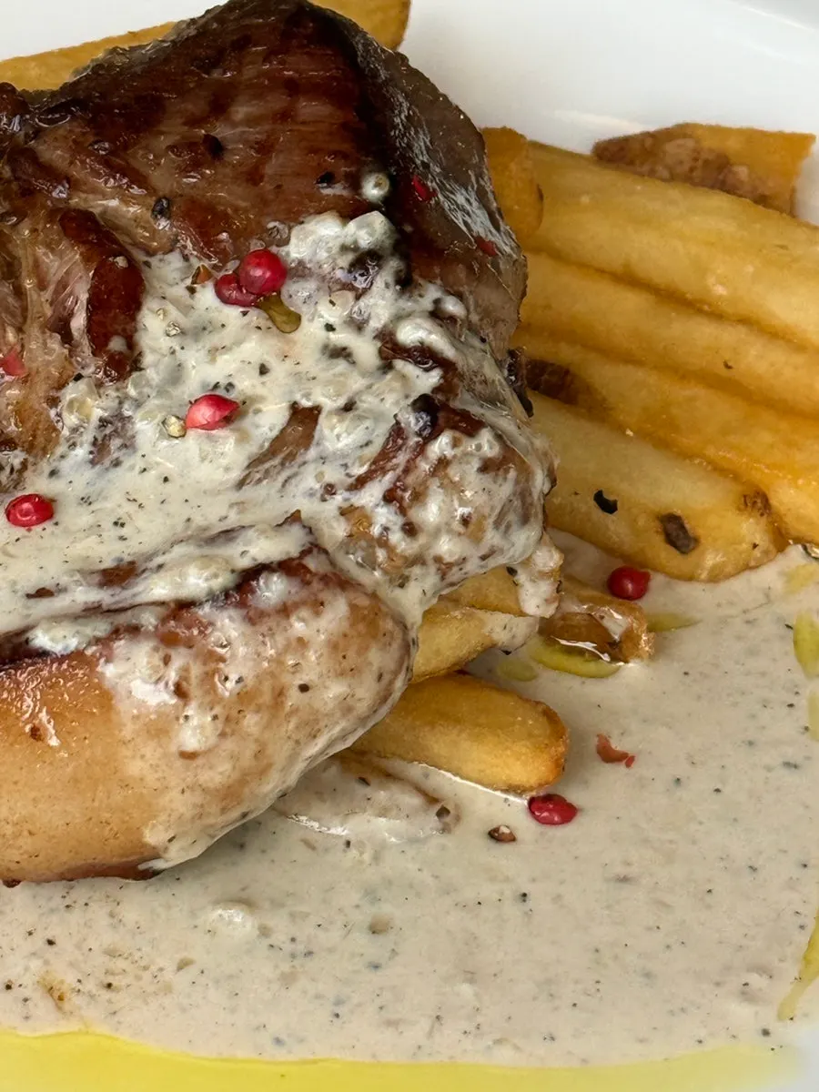 Sous-vide pork shoulder steak topped with red pepper