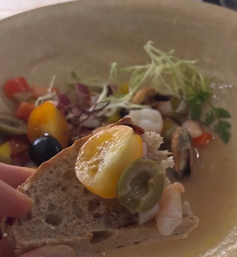 A spoonful of the seafood salad being scooped up