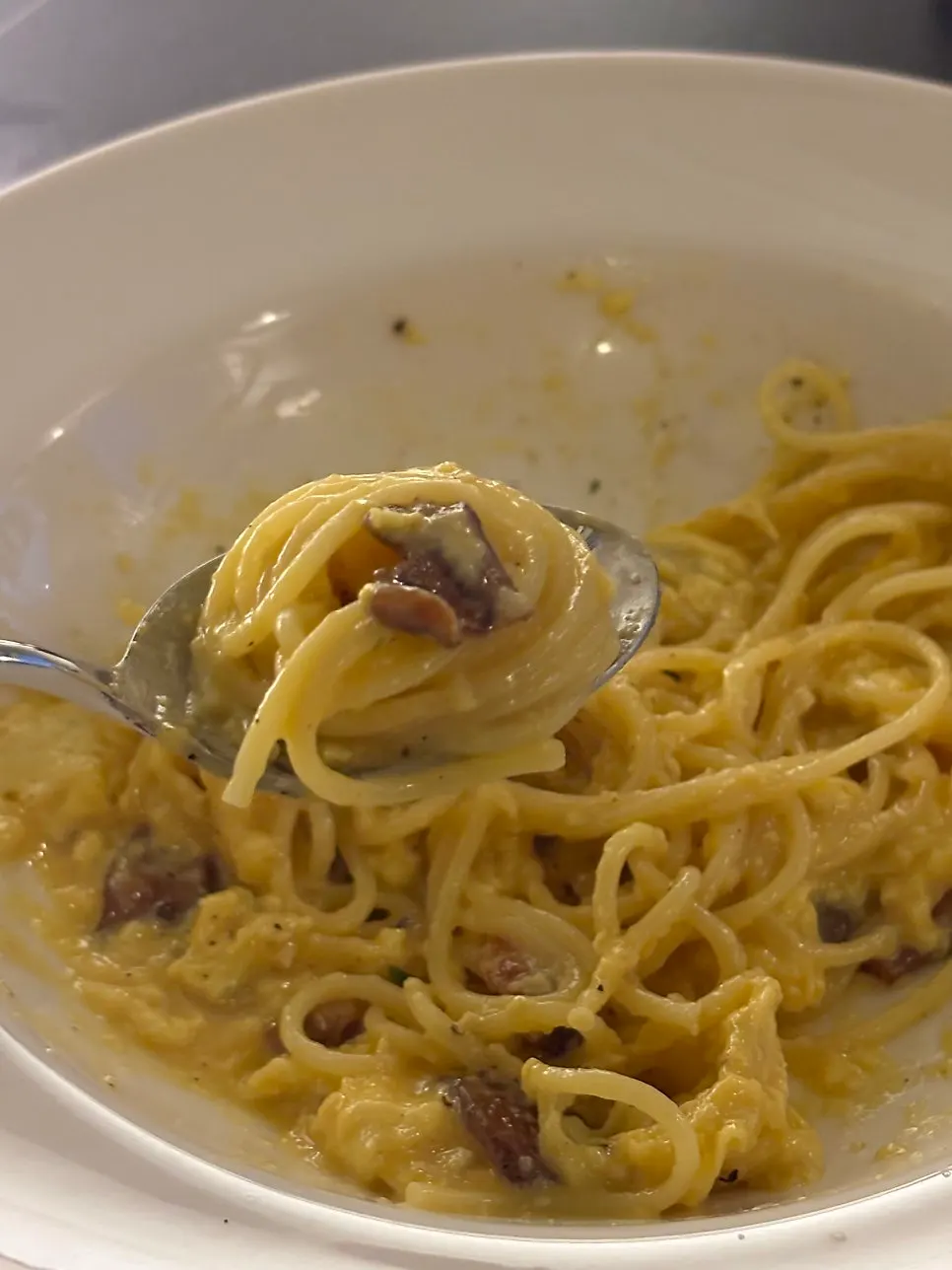 Carbonara pasta lifted up with a fork