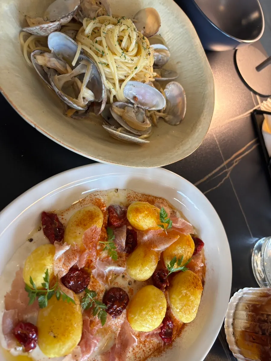 Pasta vongole con abundantes almejas, en formato vertical