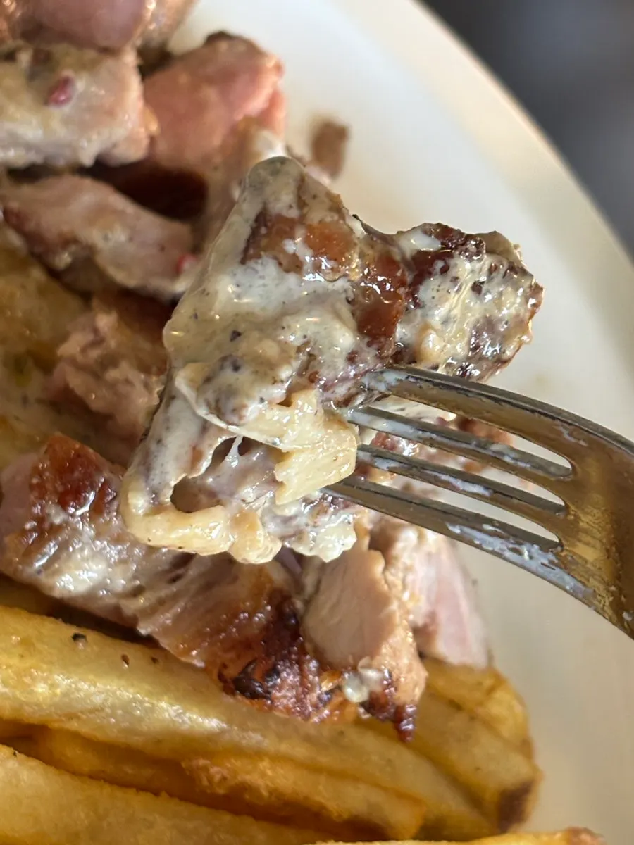 Bistec de cerdo cortado y servido por el mesero