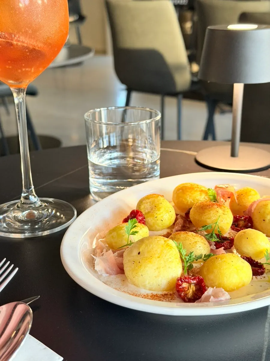 Close-up of potato salad topped with prosciutto