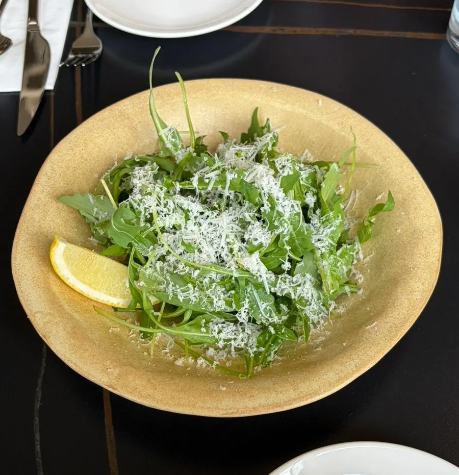 Plato de ensalada de rúcula con queso