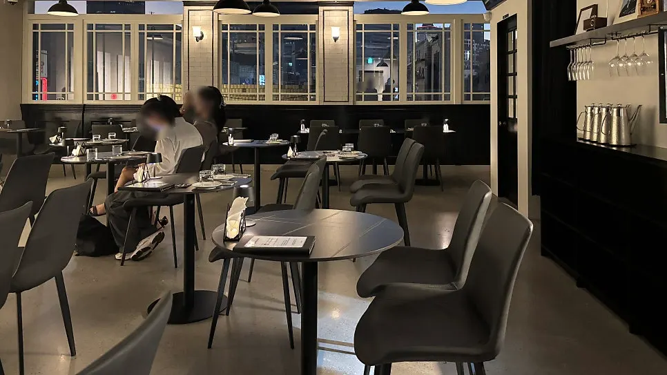 Allegro's black-toned dining room with floor-to-ceiling windows and a night view