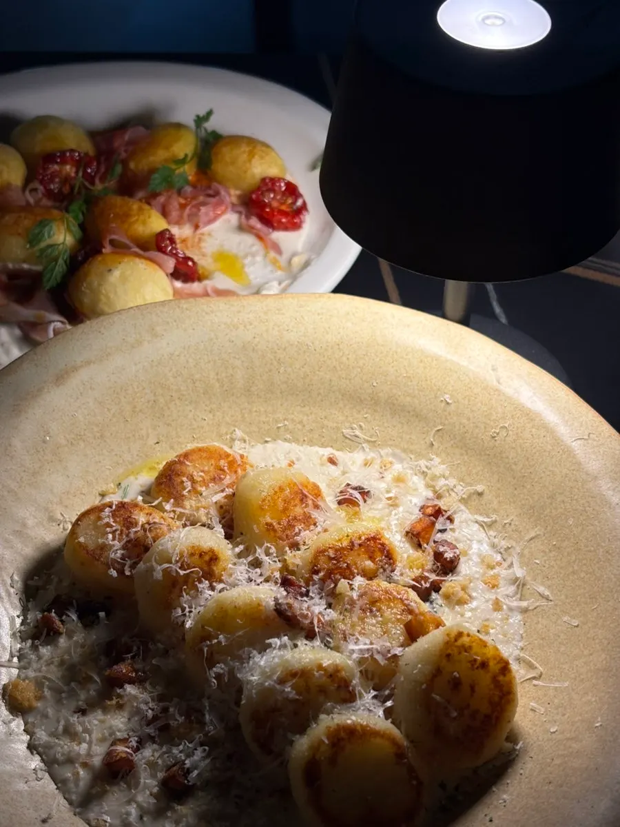 Close-up of potato and prosciutto over yogurt sauce