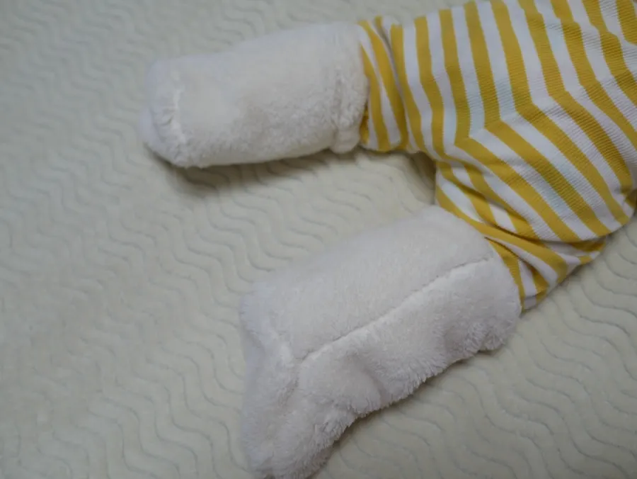 White foot warmers worn by a 6-month-old