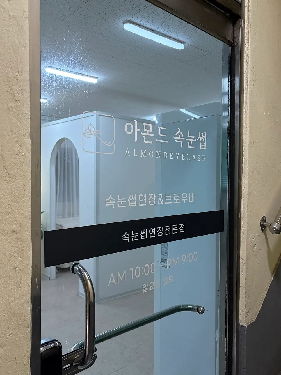 Almond Eyelashes sign and treatment info next to the ground-floor entrance