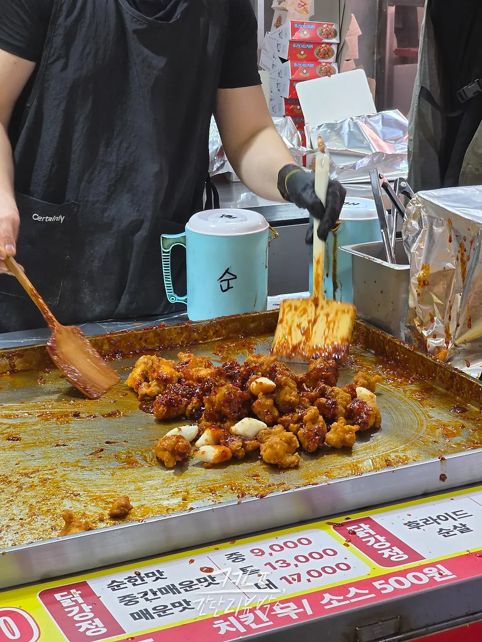 Dakgangjeong being tossed in sauce during cooking
