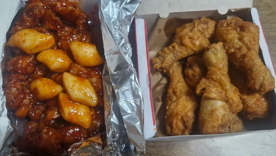 Takeout box of dakgangjeong and drumsticks opened at home