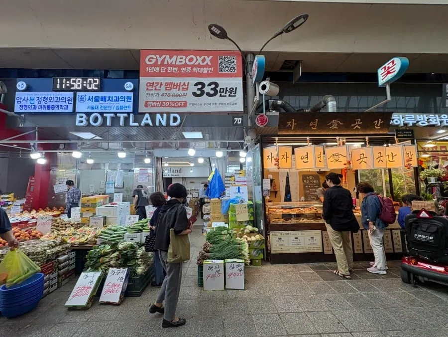 Alley with a vegetable shop and tteokgalbi restaurant in Amsa Market