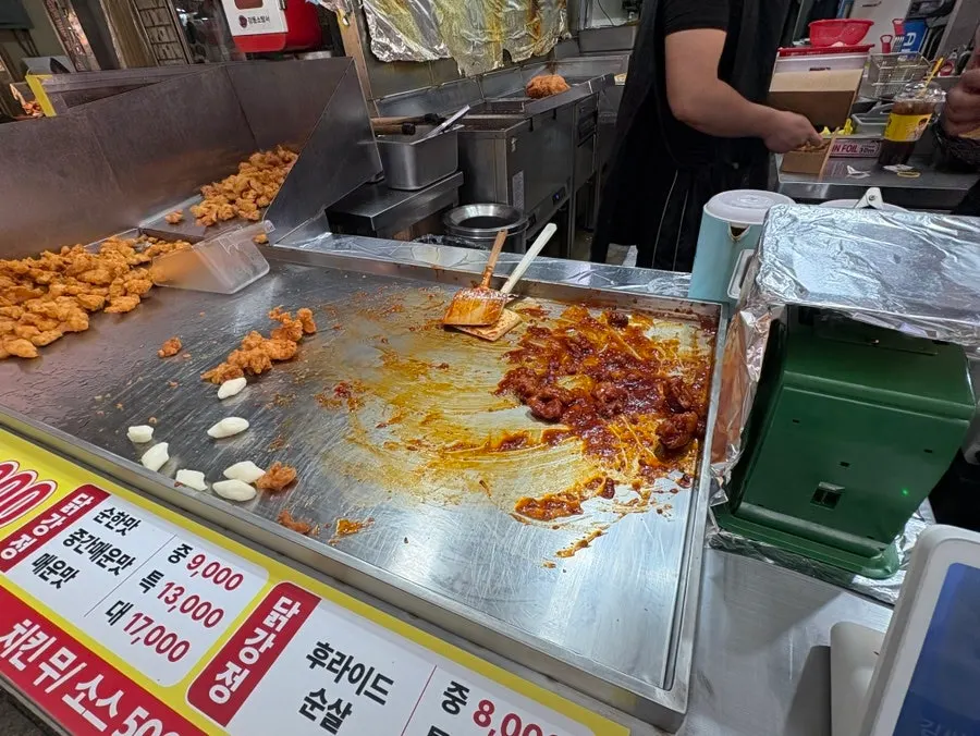 Dakgangjeong being tossed in sauce in the shop