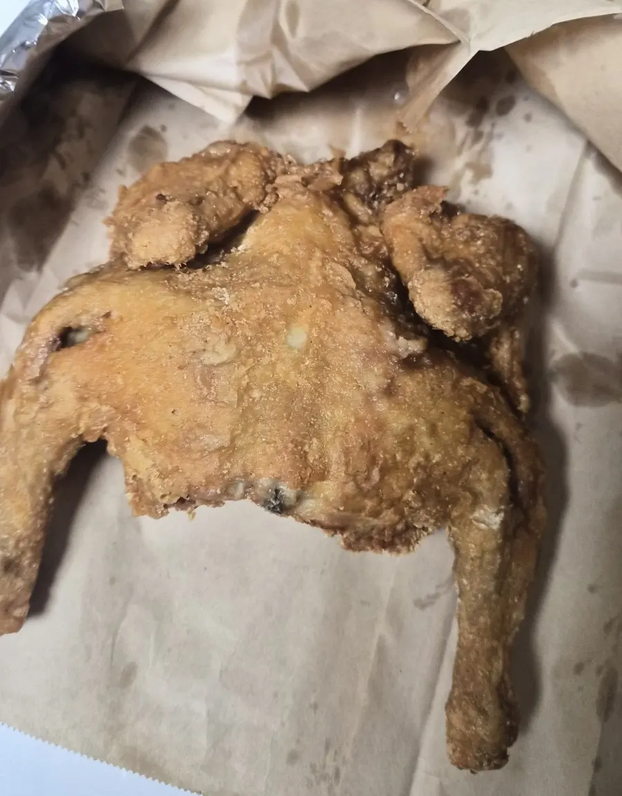 Golden fried whole chicken unwrapped at home
