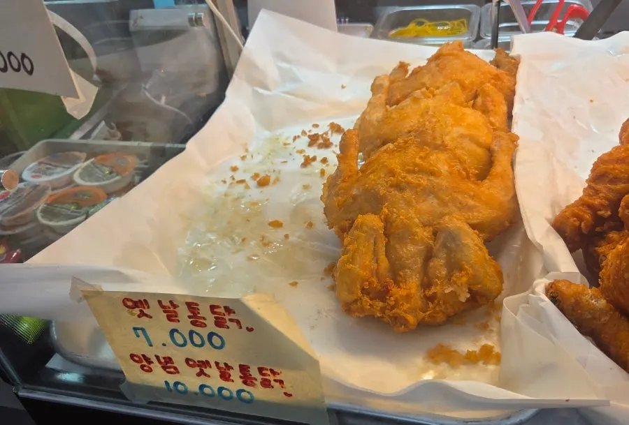Sign showing old-school fried chicken and drumstick menu items