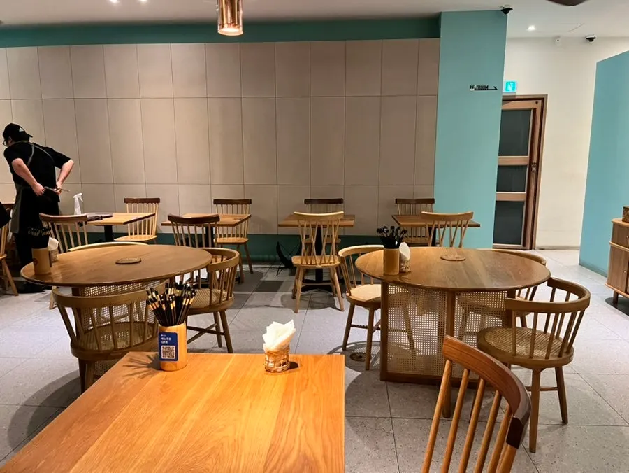 Interior with wood-toned tables and mint accent points