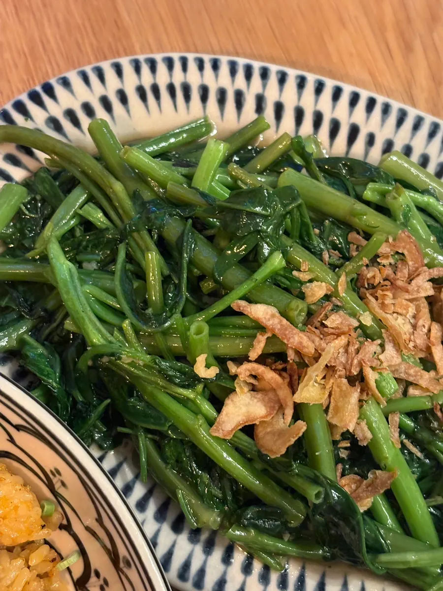 A plate of stir-fried morning glory in savory seasoning