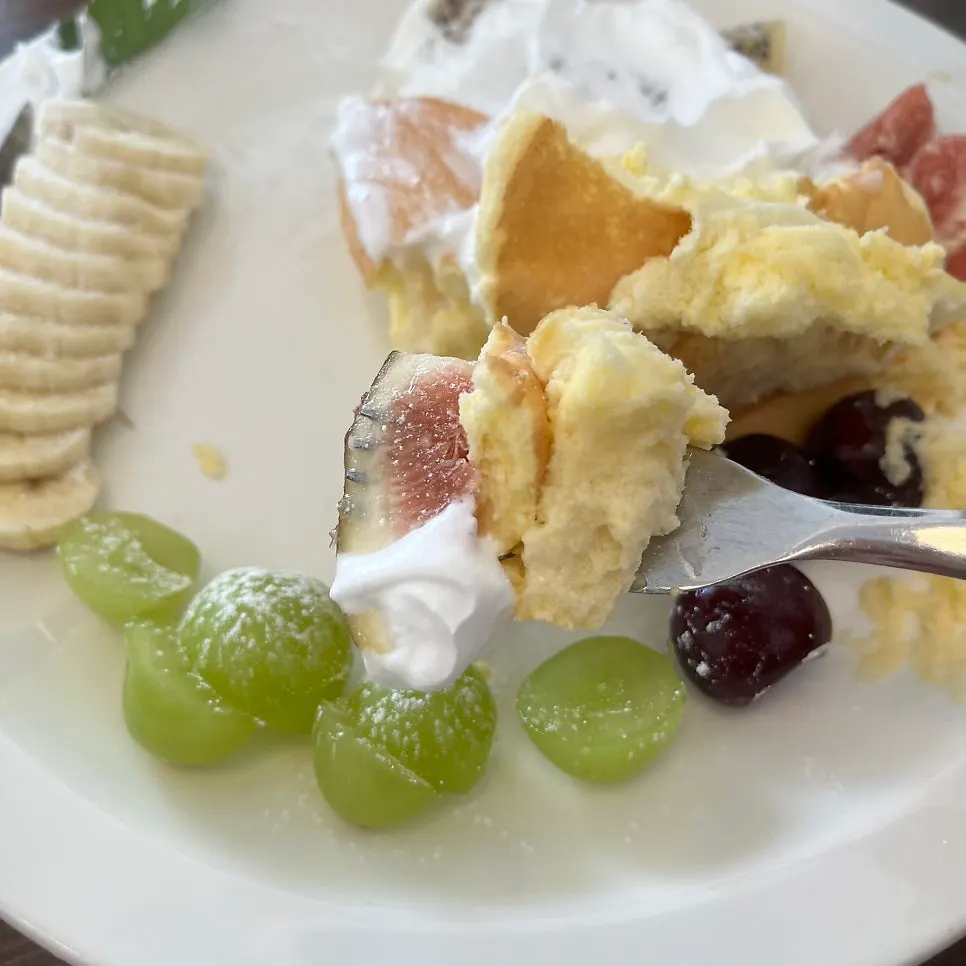 Eating the soufflé pancake topped with fruit