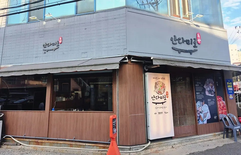 다크 브라운 원목 외벽과 흰색 간판의 안다미로 입구