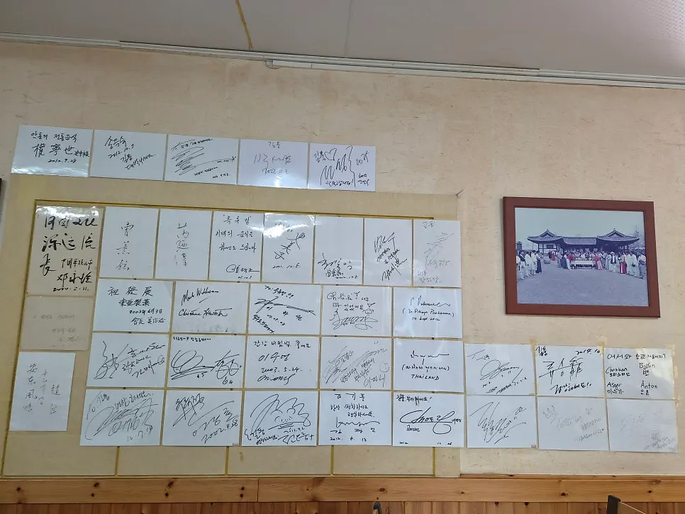 Framed autographs packed densely on a wall at Gilpung